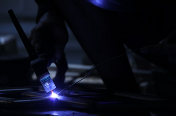 Handheld laser welder performing precision laser welding on metal